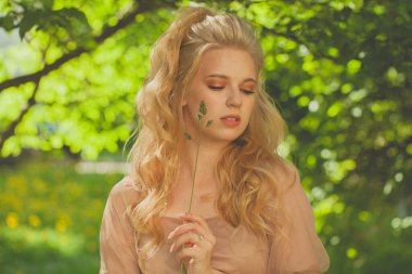 Bahar yeşili yeşillik arka planında güzel bir model kadın.