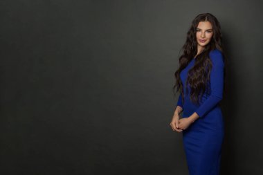 Siyah arka planda poz veren güzel bir genç kadın.