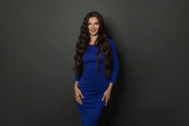 Açık tenli, uzun kıvırcık saçlı, siyah arka planda gülümseyen mükemmel bir kadın. Kendinden emin ve kaygısız.. 