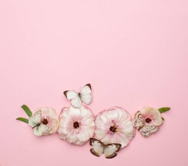 Minimum pastel pembe kart arka planında güzel bahar çiçekleri ve kelebekler