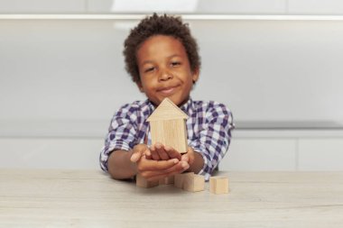 Tahta ev evdeki küçük çocuğun ellerinde.