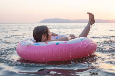 Küçük çocuk suda oynuyor ve su sıçratıyor, yaz tatili konsepti.