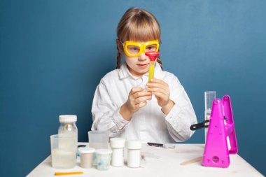 Zeki çocuk bilim deneyi yaparken eğleniyor.