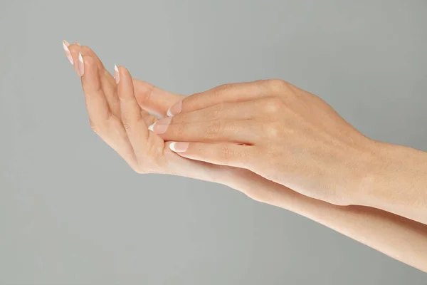 修指甲的概念 两只手 指甲修整得完美 指甲上有法式指甲 图库照片