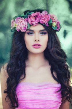 Açık havada yaz pembe çiçekli mükemmel Model kadın. Uzun kıvırcık saç modeli olan güzel kadın