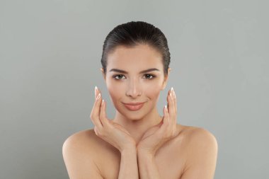 Mükemmel ciltli, güzel gülüşlü ve doğal makyajlı genç bir kadının portresi.