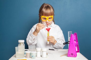 Laboratuvarda deney yapan ilginç bir öğrenci deney kabında sıvıyı inceliyor.