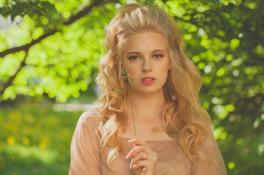 Güzel genç bir kadın bahar ya da yaz parkında bir gün geçiriyor..