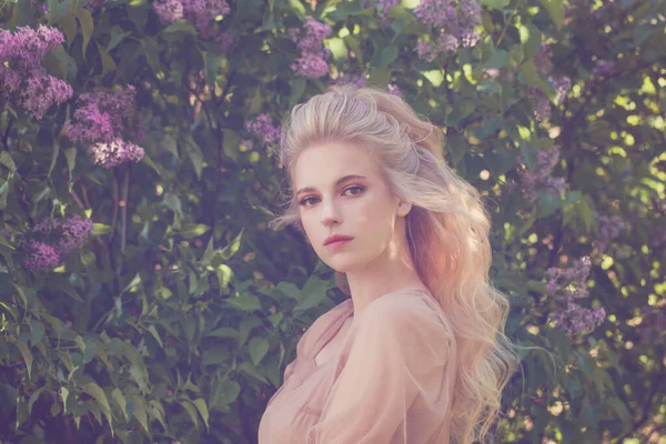 Çiçeklerin üzerinde çekici genç bir kadın. Arka planda, bahar zamanı.