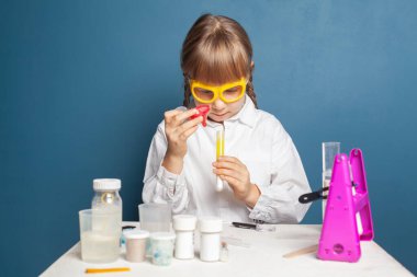 Maddeler üzerinde deneyler yapan genç bir araştırmacı kız. Bilim ve eğitim kavramı