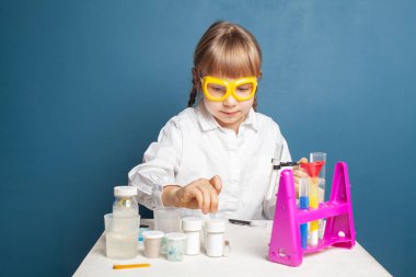 Kimya dersinde tatlı bir çocuk deney yapıyor.