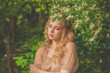 Baharın yeşillik arka planında güzel bir kadın