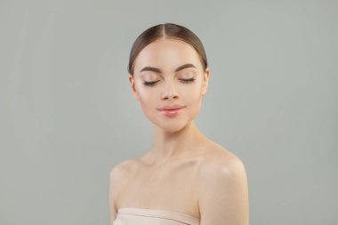 Doğal pembe parlak rujlu ve açık renk makyaj stüdyo portresi olan yeni bir kadın yüzü.