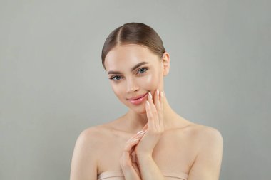 Temiz ciltli, güzel bir manken kadın, güzel bir gülümseme ve manikürlü eller. Güzellik tedavisi, kozmetoloji ve cilt bakımı konsepti