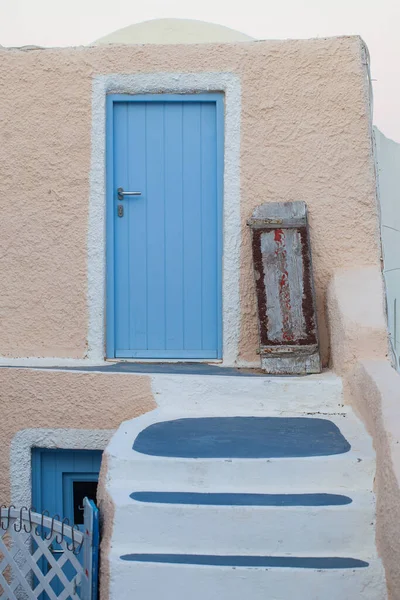 Blue wooden door and old stair in Santorini, Greece