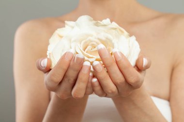 Beyaz gül çiçekli mükemmel kadın elleri. Şık moda kadın manikürü..