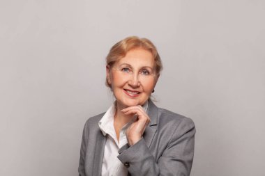 Gülümseyen, kendine güvenen, şık, olgun, orta yaşlı kadın portresi. Yaşlı kıdemli iş kadını, 60 'ların bayan yönetici yöneticisi kameraya bakıyor.