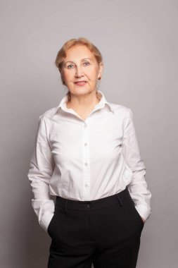 Çekici, kendinden emin, kameraya gülümseyen olgun sarışın kadın.