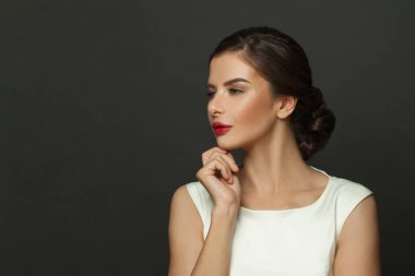 Güzel bir kadın model profili. Siyah arka planda kırmızı dudaklı esmer yüz.