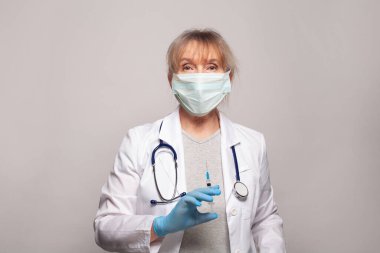 Doktor şırıngayı aşı için hazırlar.