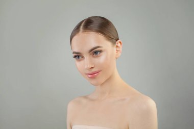 Temiz tenli, stüdyo portresi olan genç ve güzel bir kadın. Yüz bakımı. Kozmetik, güzellik ve kaplıca. Hoş bir gülümsemesi olan güzel ve çekici bir model..