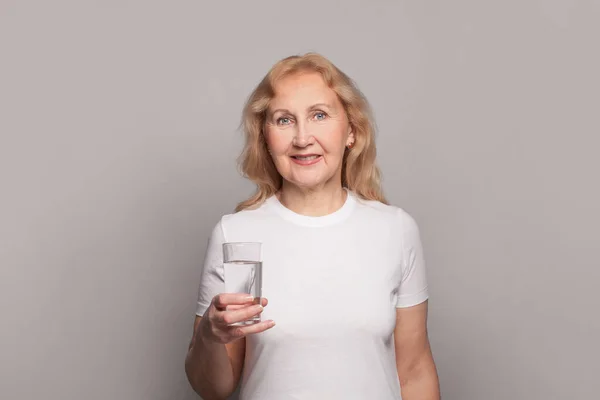 幸せな先輩女性飲料水 水のガラスを保持する熟女 — ストック写真
