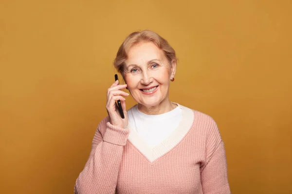 Приятно Красивый Пожилая Женщина Держит Мобильный Телефон Ярко Желтом Фоне — стоковое фото