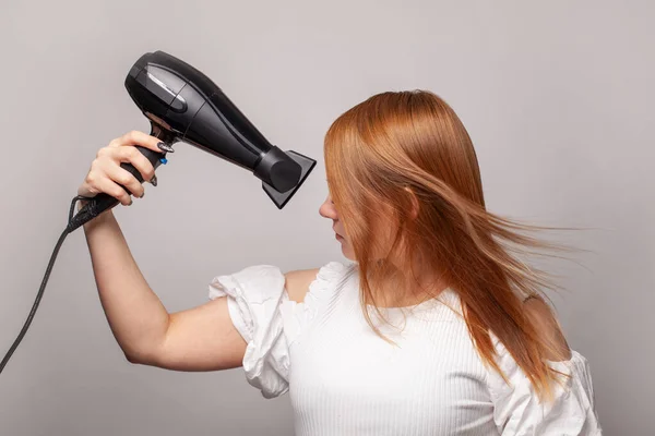 Μόδα Μοντέλο Γυναίκα Χρησιμοποιώντας Στεγνωτήρα Μαλλιών Γκρι Φόντο Στούντιο — Φωτογραφία Αρχείου