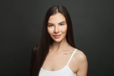 Koyu renk saçlı güzel bir yüz portresi. Mükemmel cildi ve doğal makyajı olan zarif ve çekici bir kadın. Güzellik salonu ve kozmetik konsepti