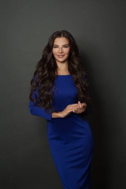 Profesyonel makyajlı, genç, güzel esmer bir mankenin portresi, modaya uygun dalgalı saç modeli ve klasik elbise içinde mükemmel bir ten.