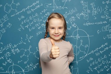 Gülümseyen ve fen bilgisi formüllerinde parmağı olan mutlu akıllı kız.