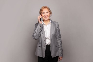 Zeki, mükemmel, son sınıf kadın telefonu. Akıllı telefonlu olgun bir iş kadını.