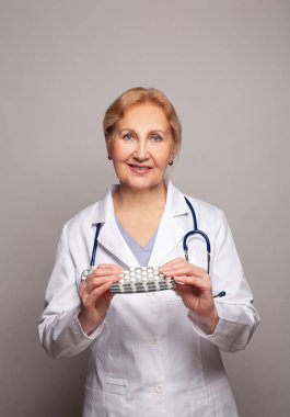 Kadın doktor elinde hap tableti kabarcıkları tutuyor. Hayat kurtarma servisi, yasal eczane, reçete ve hastalık iyileştirme konsepti
