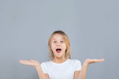 Happy shocked excited surprised child girl holding empty open hands.Childhood lifestyle concept. Mock up copy space. 
