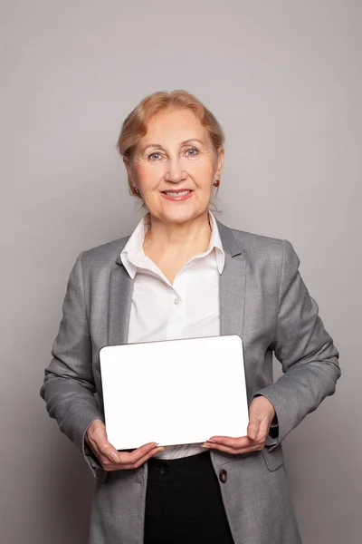 Успешная Старшая Деловая Женщина Отдыхает Пустой Цифровой Планшет Стоя Сером — стоковое фото