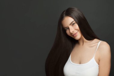 Siyah arka planda mükemmel sağlıklı saç stili olan sevimli, güzel bir kadının portresi.