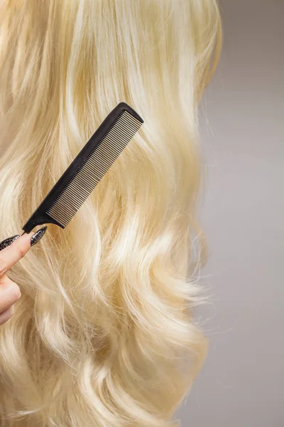 Grzebień Długie Kręcone Blond Włosy Szarym Tle — Zdjęcie stockowe