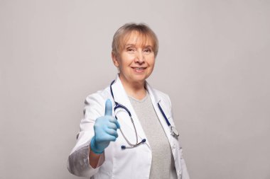 Mutlu doktor ya da pratisyen doktor başparmağını kaldırıp gülümsüyor.