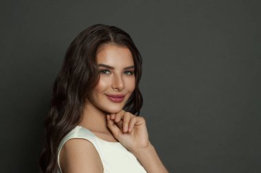 Moda makyajlı, saç stili, gülümseyen ve kamera resimlerine bakan muhteşem bir kadın.