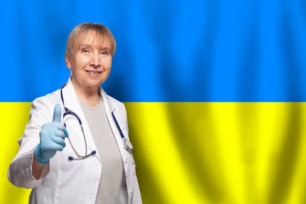 Uśmiechnięta Dojrzała Lekarz Kobieta Trzyma Stetoskop Fladze Ukrainy Tle — Zdjęcie stockowe