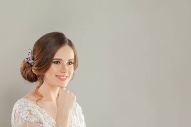 Sağlıklı güzel bir kadın açık gri afişte gülümsüyor.