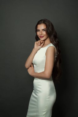 Siyah duvar arkasında duran zarif, şık esmer kadın.