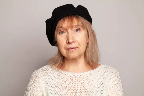 Portrait of 60 year old senior woman on white background