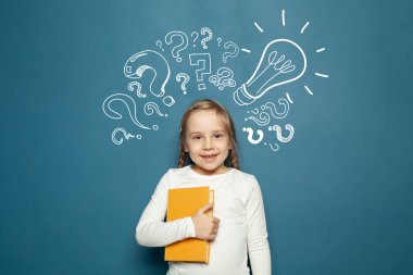 Sarı kitabı, ampulü ve tebeşir soru işaretleriyle gülümseyen neşeli çocuk okulu öğrencisi. Beyin fırtınası, problem ve çözüm