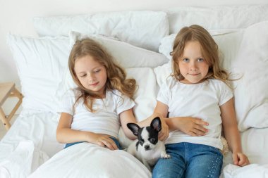 Beyaz köpek besleyen sevimli küçük kız kardeşler