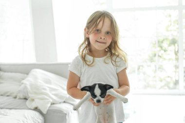 Yavru köpeğini kucağına alan küçük kız.