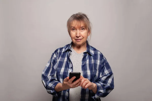 灰色のバナーの背景に電話でシニア女性メッセージング — ストック写真