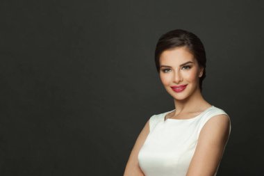 Young perfect woman with makeup and trendy hairstyle smiling on black background portrait