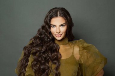 Young glamorous model woman with long wavy hair smiling, beauty portrait. Fashion and hair care concept. 