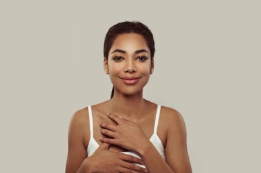 Cute young african american woman with healthy clean skin and natural makeup on white background